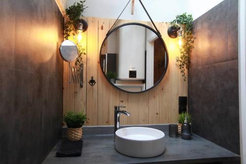 La salle de bains est pourvue d'un lavabo et d'un miroir. dans l'établissement Love Room Romantique Les Petits Plaisirs, à Angers