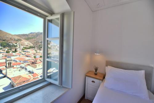 a bedroom with a bed and a large window at Onar Hydra in Hydra