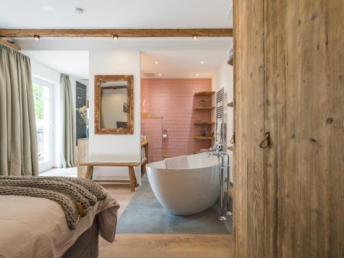 un bagno con una grande vasca e una camera da letto di Lieblingsplatz - Traumhafte Wohnung mit Sauna - 200m vom Strand a Rerik