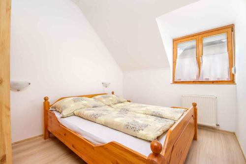 1 dormitorio con cama de madera y ventana en Apartment in Balatonmariafürdo 19493 en Balatonmáriafürdő