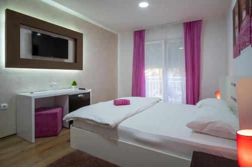 a bedroom with a bed and a sink and a tv at Apartments Sweet Dreams in Trebinje