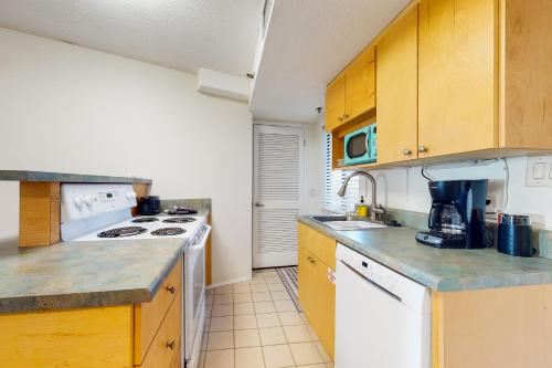 a kitchen with a sink and a stove top oven at The Commodore in Panama City Beach
