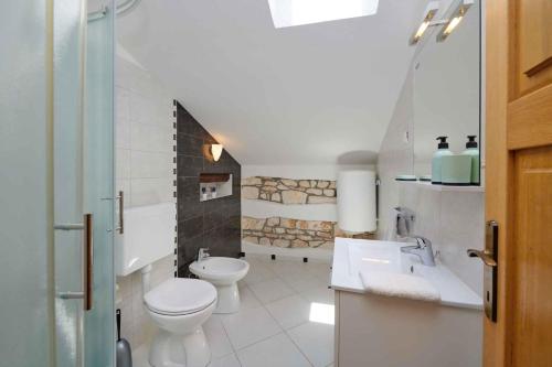 biała łazienka z toaletą i umywalką w obiekcie Holiday home in Medulin/Istrien 9006 w Medulinie