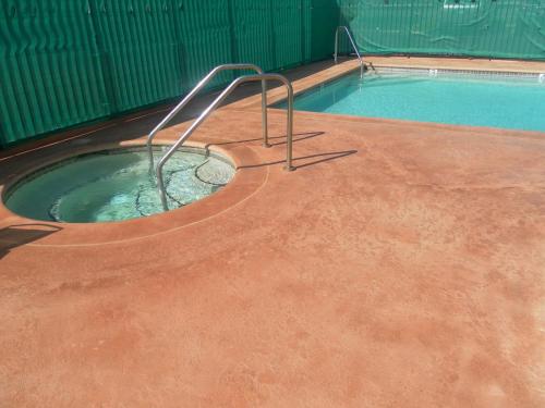 een zwembad met een hot tub op de grond bij Ocean Gateway Inn in Santa Paula