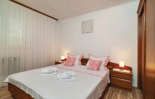 1 dormitorio con 1 cama blanca grande con almohadas rosas en Apartment on the hill overlooking the sea, en Podstrana