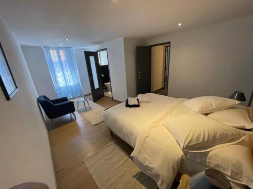 特雷布的住宿－La pause du canal，卧室配有一张白色大床和一把椅子