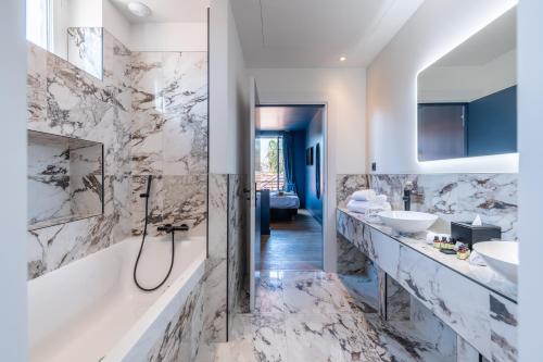a bathroom with two sinks and a tub and a shower at Boutique Hotel Nice Côte d'azur in Nice