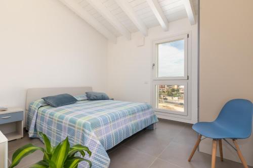 a bedroom with a bed and a blue chair at Bcolors Rooms, Selargius Is Corrias in Pirri
