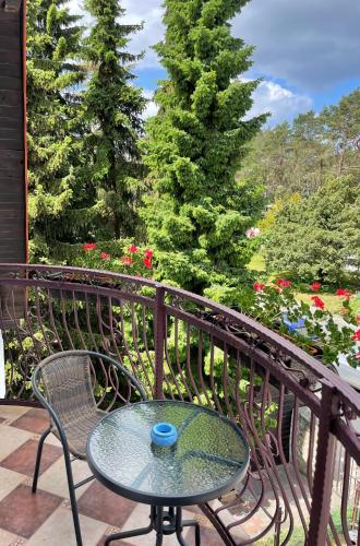 a table and chairs on a balcony with flowers at Willa 4 Pory Roku & Uznam in Świnoujście