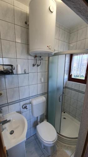 a small bathroom with a toilet and a sink at Apartments Sime in Sukošan