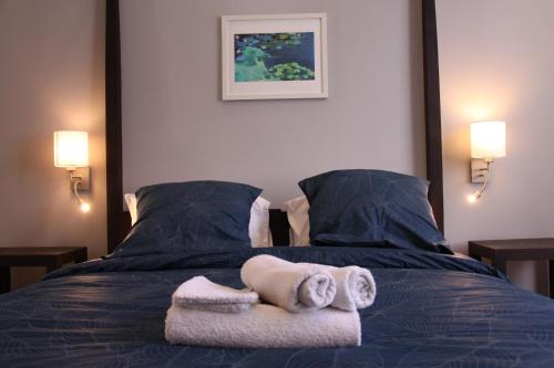 a bedroom with a bed with towels on it at Le Jardin de Ligny in Saint-Omer