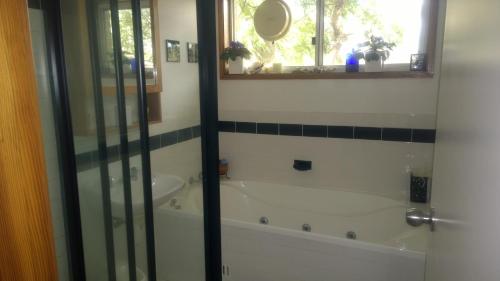 a bathroom with a bath tub and a window at Linley House in Sydney