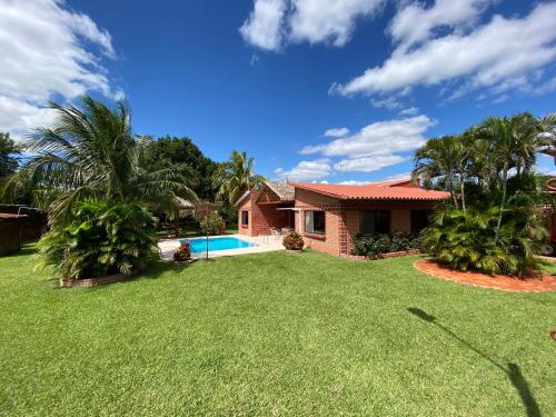 a house with a yard with a swimming pool at Casa por Temporadas in Santa Cruz de la Sierra
