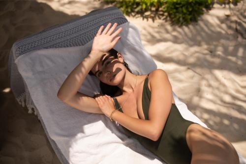 a woman laying on top of a beach towel at Encantada Tulum in Tulum