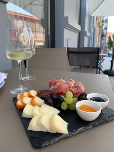 a plate of cheese and grapes and a glass of wine at Rio da Vila in Porto