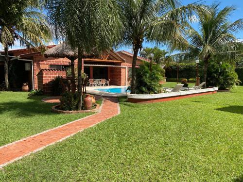 a house with a swimming pool and palm trees at Casa por Temporadas in Santa Cruz de la Sierra