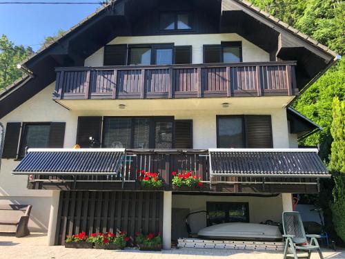 a house with a balcony with flowers on it at SavaDolinka House in Mojstrana