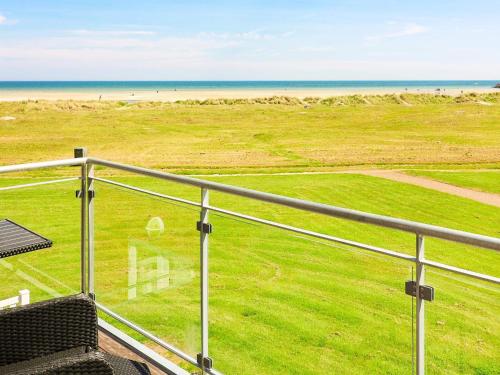 uma varanda com vista para a praia e para o oceano em 6 person holiday home in Hadsund em Hadsund