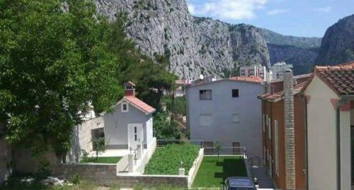 a group of buildings with a mountain in the background at Apartmani ANITA in Omiš