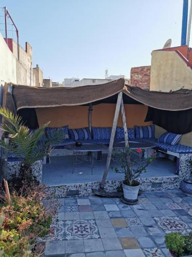 a patio with a gazebo with blue pillows at Bayt Alice Hostel in Tangier