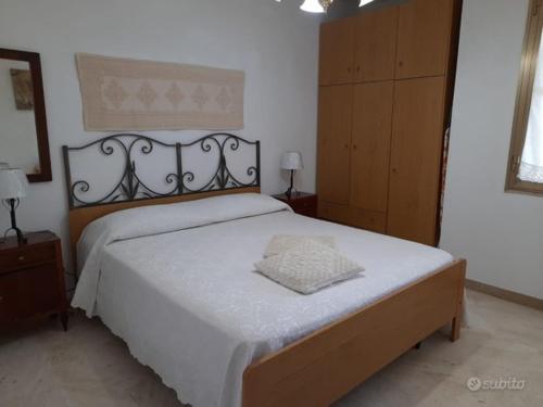 una camera da letto con un grande letto con una coperta bianca di Casa Vacanze Arba Girasole a Girasole