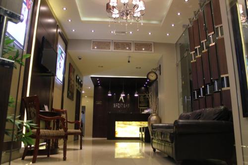 a living room with a couch and a chandelier at Africana Hotel in Dubai