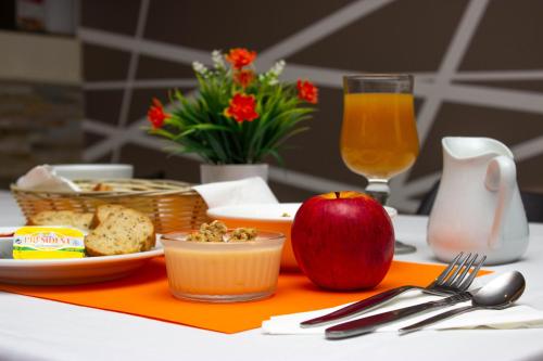 an apple and a plate of food on a table at Hotel Le Paris in Noumea