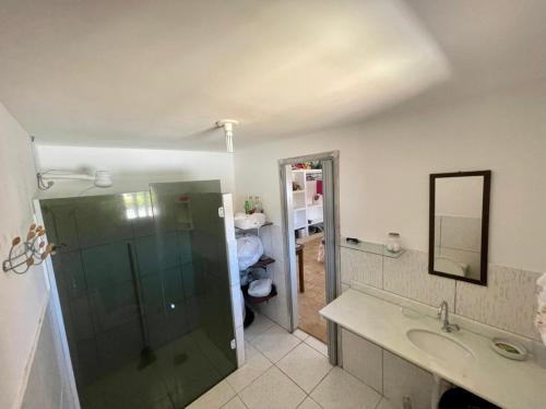 a bathroom with a shower and a sink and a mirror at Casa de praia em Cotovelo in Parnamirim