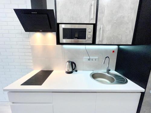 a kitchen counter with a sink and a microwave at Апартаменты в Аркадии - Arcadia Sky Apartments in Odesa