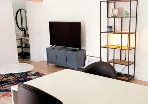 a living room with a flat screen tv on a tv stand at Luisa's Loft in Setúbal