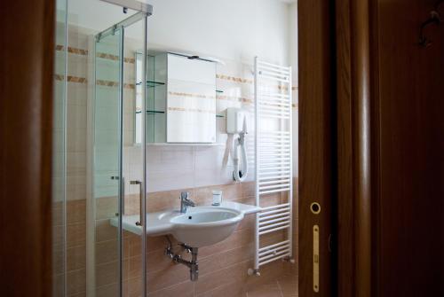 a bathroom with a sink and a glass shower at B&B Angela in Scanno