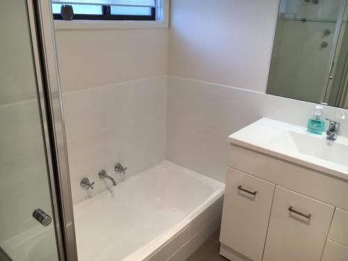 een witte badkamer met een douche en een wastafel bij 80 LaRonde Carrickalinga in Carrickalinga
