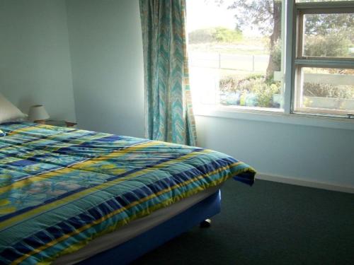 a bedroom with a bed next to a window at 77 Gold Coast Drive in Carrickalinga