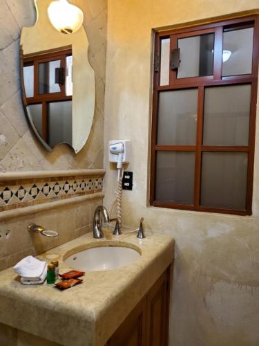 a bathroom with a sink and a mirror at Hotel Villarreal in Zacatecas