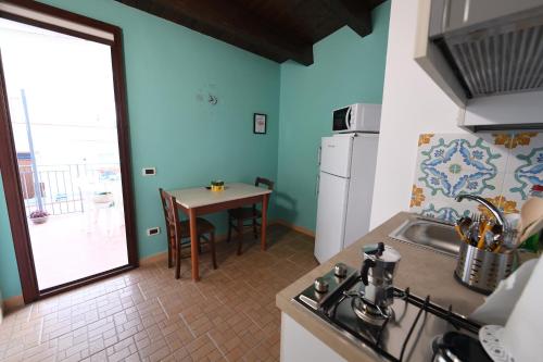 eine Küche mit einem Waschbecken und einem Tisch mit einem Tisch in der Unterkunft By the Sea Apartment #4 in Terrasini