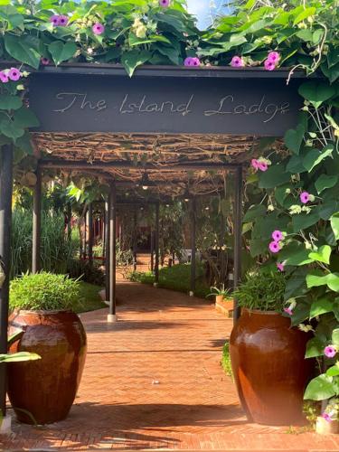 an entrance to a garden with two large flower pots at The Island Lodge in My Tho