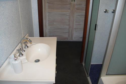 een badkamer met een witte wastafel en een douche bij The Beach Shack - OCEAN VIEWS, CLOSE TO THE BEACH in Guilderton