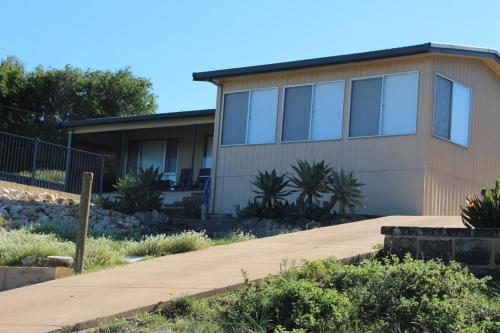 a house with a sidewalk in front of it at The Beach Shack - OCEAN VIEWS, CLOSE TO THE BEACH in Guilderton