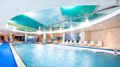 una piscina en un hotel con sillas y una piscina en Delpino, en Sokcho