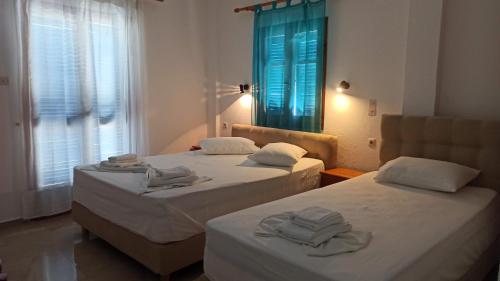 duas camas num quarto de hotel com toalhas em Sifis em Lutró