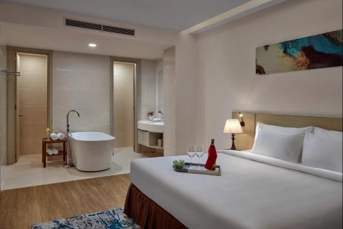 a bedroom with a large bed and a bath tub at Khách sạn SAM Quảng Bình in Dong Hoi