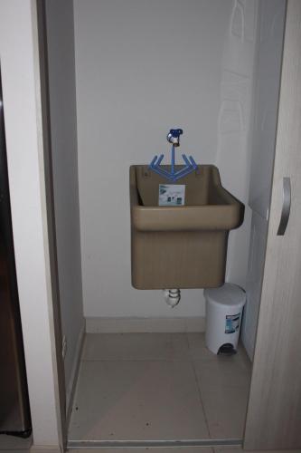 a bathroom with a sink and a trash can at Amaluc zac in Jacó