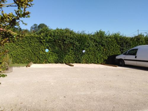a white van parked in front of a hedge at Chalet La Bachole in Charancieu