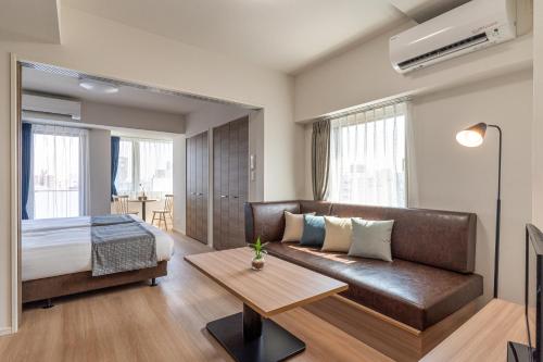 a bedroom with a couch and a bed and a table at BON Tokyo Asakusa in Tokyo