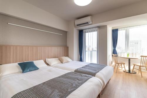 a bedroom with a large bed and a table at BON Tokyo Asakusa in Tokyo