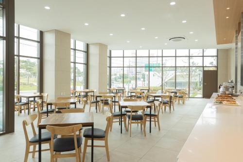 a dining room with tables and chairs and windows at CENTUMMARK Hotel YangYang in Yangyang