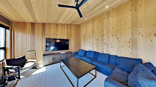 a living room with a blue couch and a tv at Beautifully remodeled 3 Bedroom Condo in Mammoth Lakes