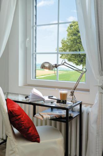 a desk with a lamp and a chair in front of a window at Landhaus Heidekrug in Hildesheim