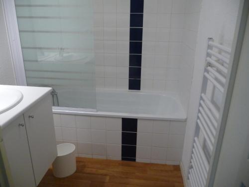 a bathroom with a bath tub and a sink at Résidence Goélia Belle Epoque in Mers-les-Bains