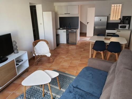 sala de estar con sofá, mesa y cocina en Appartement avec parking privatif à Collioure, en Collioure